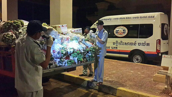 货检局官员拦截汽车，检查水果蔬菜，以证实是否含有化学成份。 （柬埔寨星洲日报）