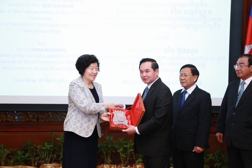 肯文松和孙春兰相互交换纪念品。