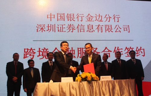 中国银行金边分行行长陈长江（前右）与深圳证券信息有限公司代表交换协议文件。