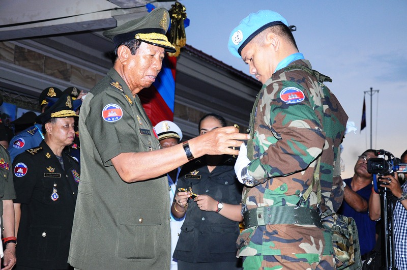 狄班为柬维和官员佩戴勋章。 （柬埔寨星洲日报）