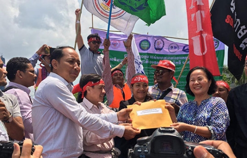 艾吞(左)代表工人向人民党议员提呈请愿书。