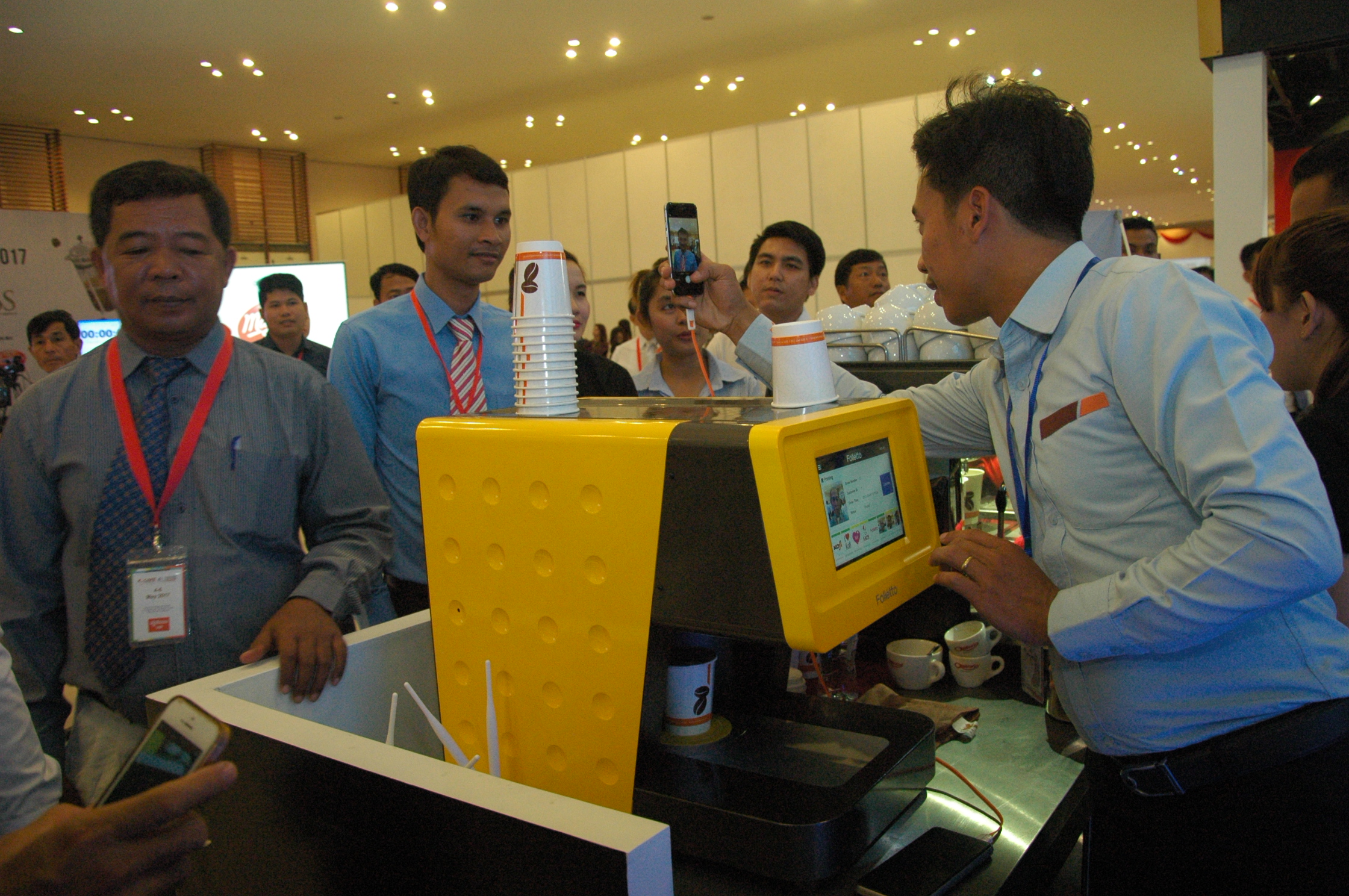 工作人员示范人脸咖啡机操作方式。