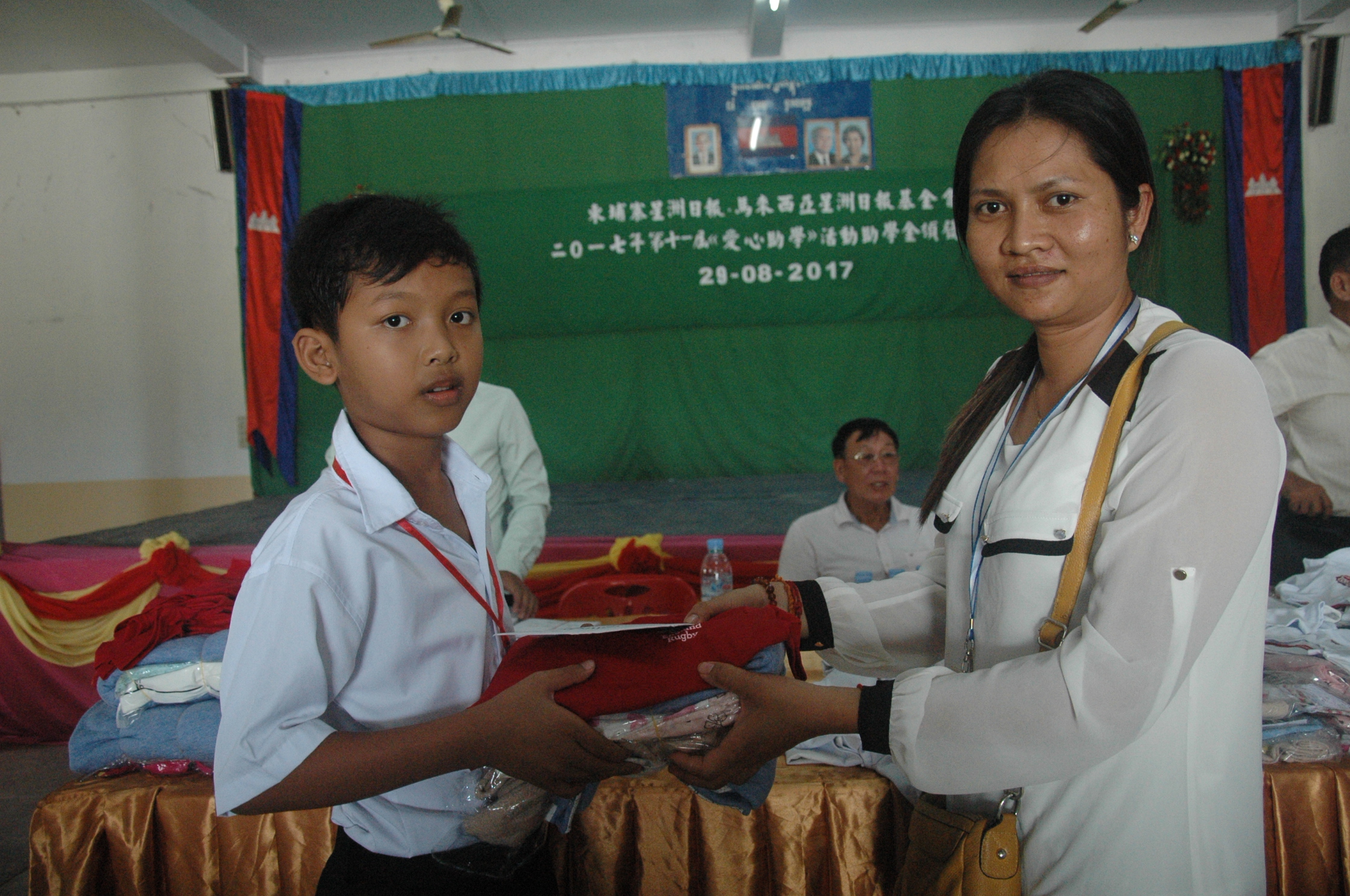 培成学校新上任校长沈贵花代表移交助学金与物资给该校受益学生。