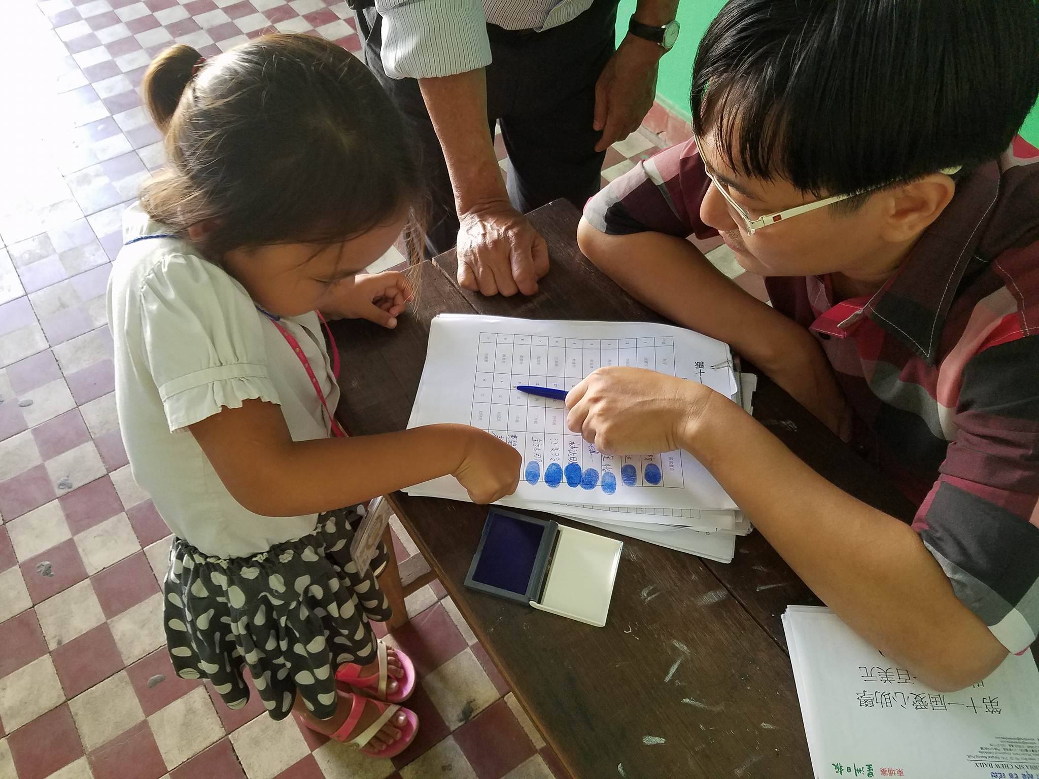 小学生盖上手印，再领取助学金。