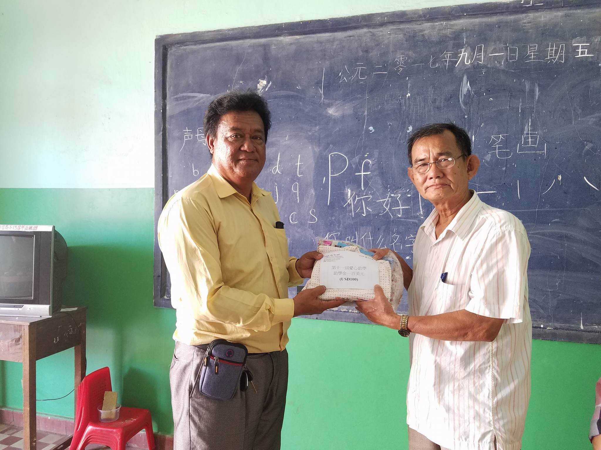 华侨学校校长代表缺席的贫困生代收助学金。