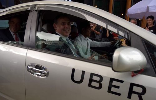 美国驻柬大使威廉海特（前座）和优步亚太区首席商务员布洛克斯（后座）试坐优步。（图：法新社）