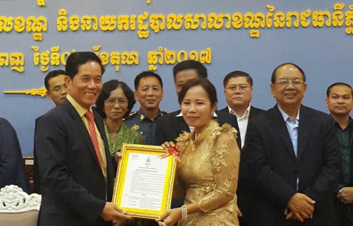 金边市长坤盛（左）颁发委任状予其中一位新任副区长。