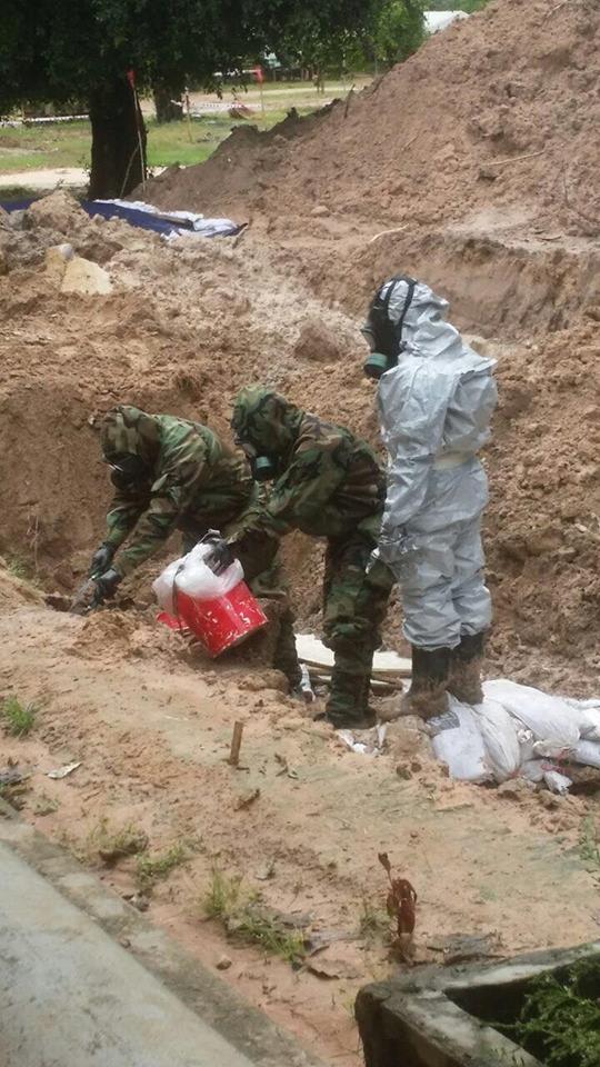 身穿化武防护衣的拆除人员，正在清理首枚化学弹。（图：柬埔寨星洲日报）