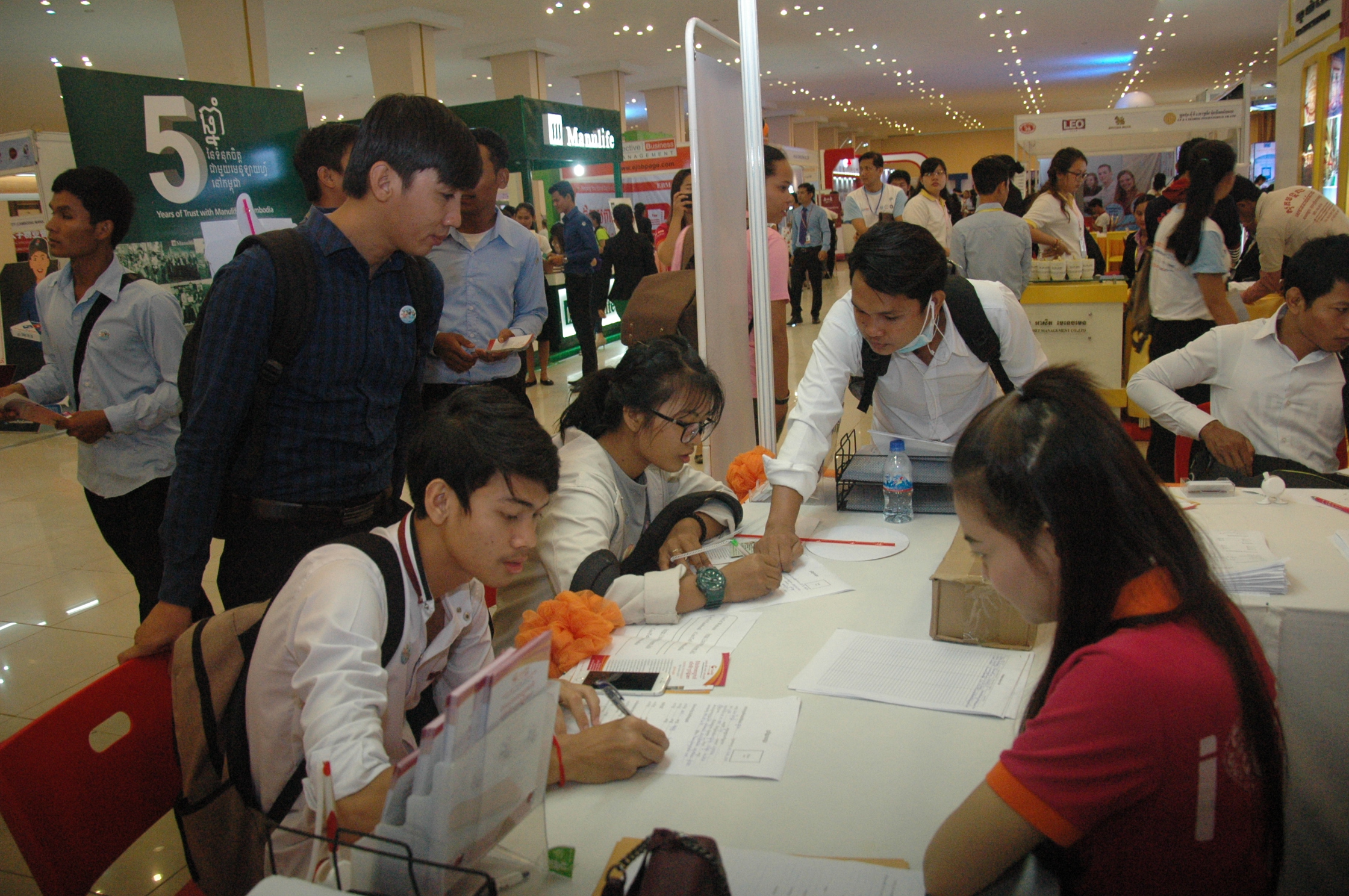 觅职青年在职业展上填写应征表格。 （图：柬埔寨星洲日报）