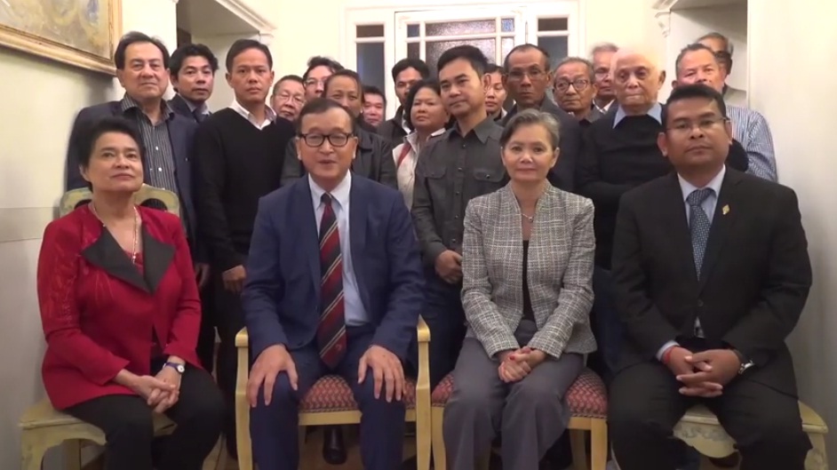 前救国党主席沈良西（前左二）在大批流亡海外的救国党议员陪同下，通过视频向救国党支持者发表声明。（图：柬埔寨星洲日报）
