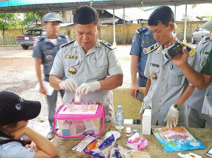 货检局官员对起获的香肠和火腿样本进行化验。