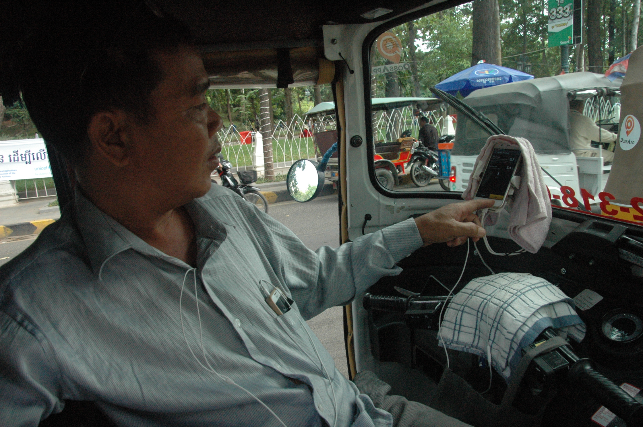 在塔仔山公园接客的印度嘟嘟车车夫莫利向本报介绍软件功能。