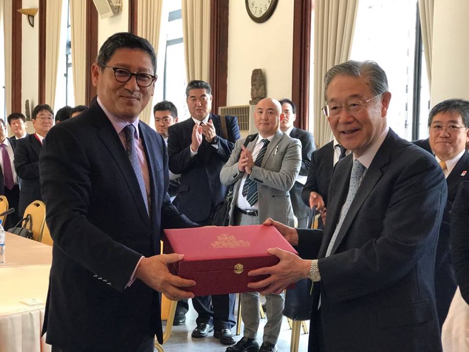 柬埔寨发展理事会秘书长速真达索彼（左）和日本77银行代表交换纪念品。