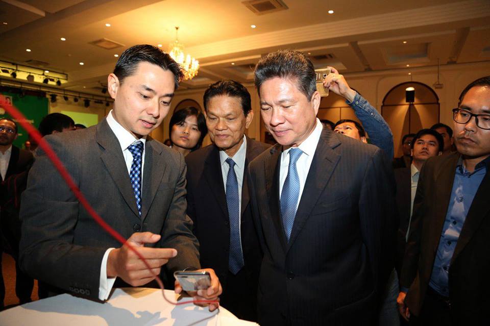 Grab公司负责人汤毅伟（左）向孙占托介绍Grab召车系统。