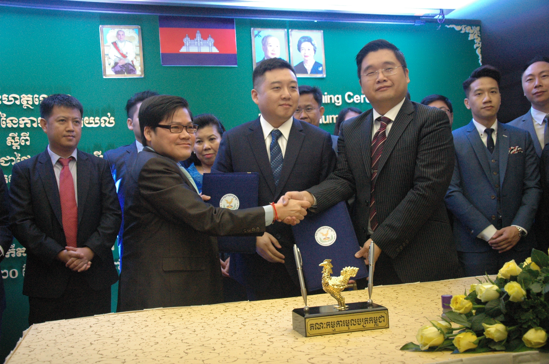 柬埔寨证券委员会总监苏速杰（左）和Camnext Global公司代表交换合作文件。