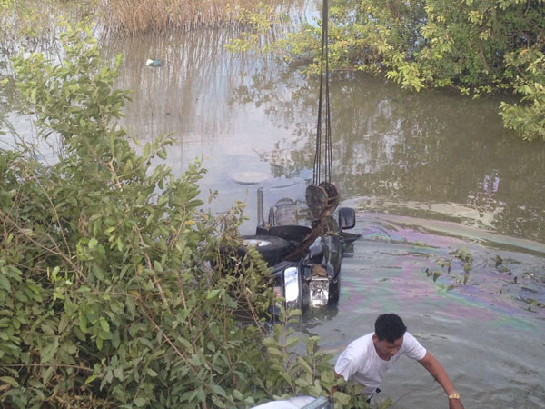 图为执法人员把汽车吊上岸。