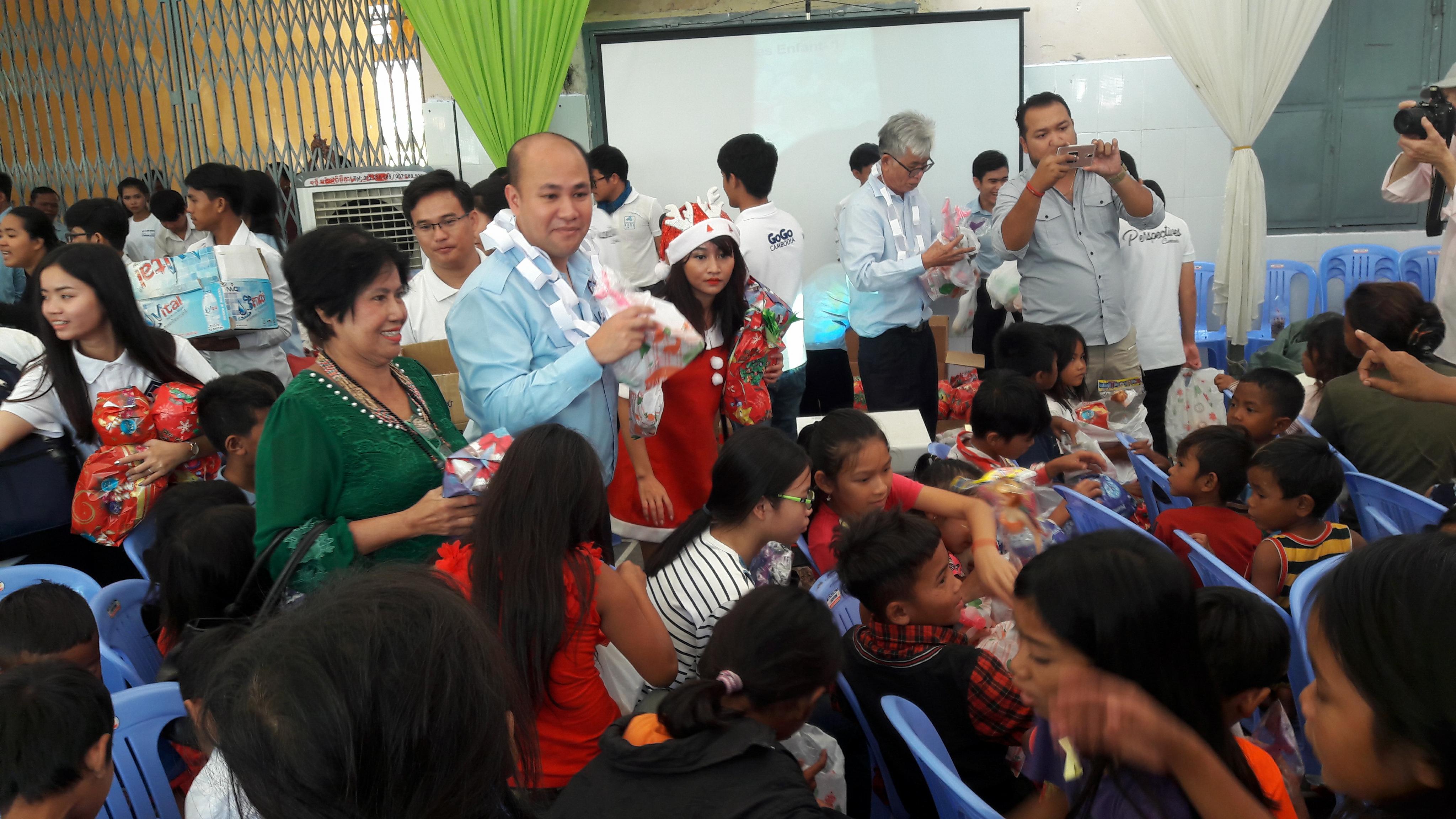 洪玛尼及史玉华会长为孤儿发放圣诞节礼物。 （图：柬埔寨星洲日报）