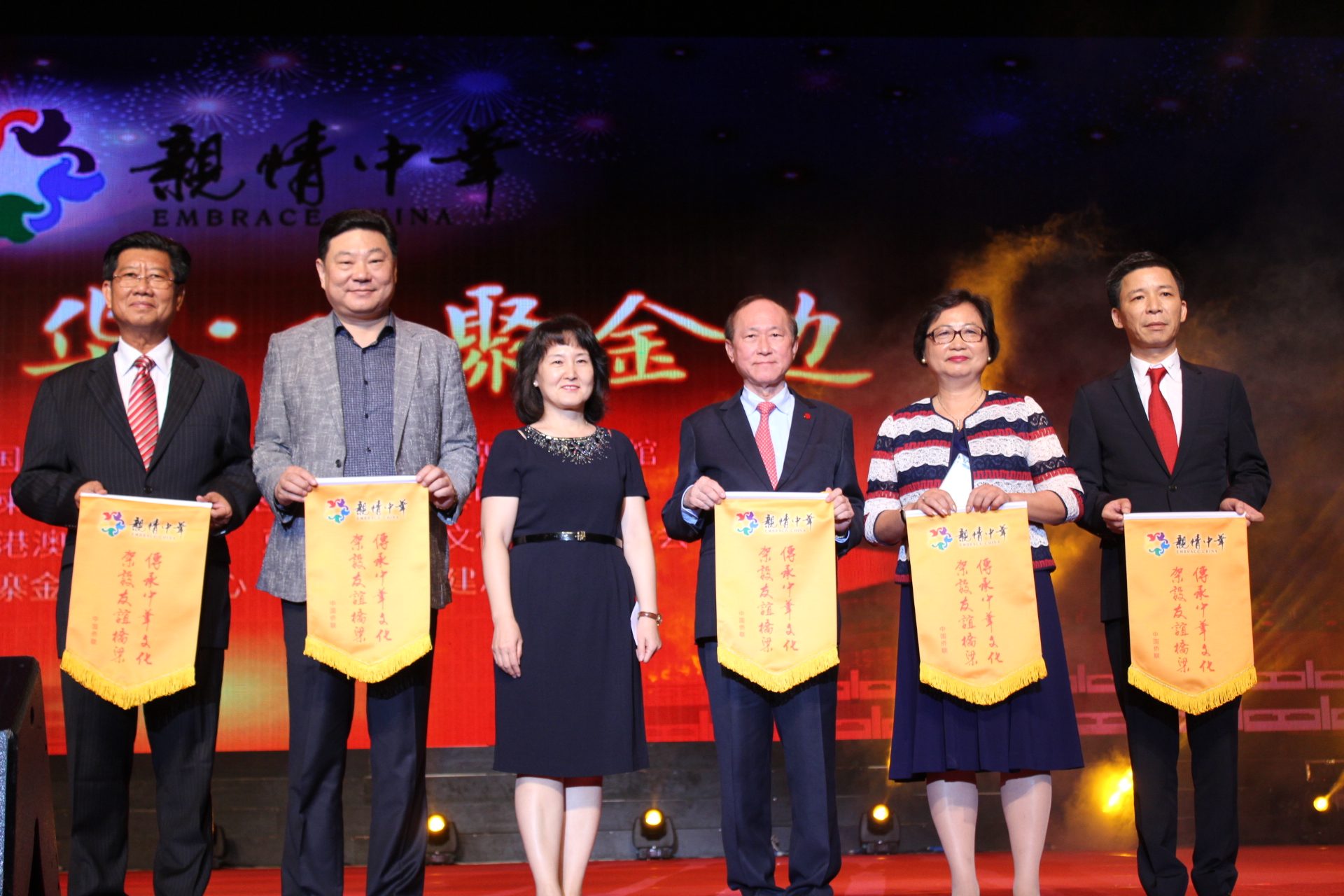 团长邢砚庄（左三）向承办此次演出的侨团授旗。